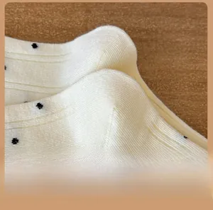 Vista macro dettagliata del tallone in maglia a coste su calzini bianchi a pois neri