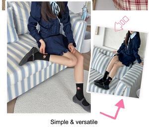 Détail de chaussettes noires à bord blanc avec broderie chiot mignon style collège