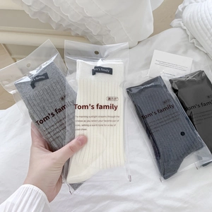 Grey and neutral mid-calf cotton rib socks set in individual minimalist packaging