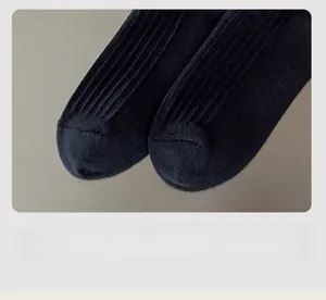 Detailed macro view of the smooth toe seam and vertical knit texture on black crew socks