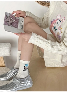 Detail of white mid-calf socks with cute cartoon rabbit embroidery and silver shoes