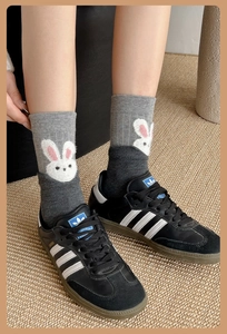 Detailed view of grey mid-calf socks with 3D white rabbit embroidery and color stitching
