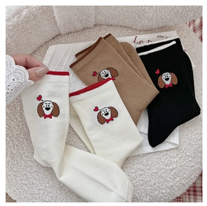 Détail de motifs de chiens brodés sur des chaussettes en coton sur une texture douce