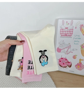 Detail of stacked cotton socks featuring cute cartoon cat and rabbit prints in soft pastel tones