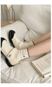 Detail of socks with Hello Friend embroidery and ruffled trim worn with Mary Jane shoes