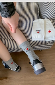 Detail of grey and white knit socks with red heart I Love Paris embroidery and ribbed cuffs