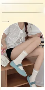 Details von weißen Baumwollsocken mit gepunktetem Spitzenbesatz und süßen Schleifen