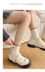 Detail of off-white knit socks with colorful speckles and brown ruffle edges