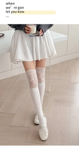 Détail de chaussettes hautes blanches avec dentelle florale et mailles verticales