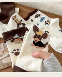 Detailed close-up of cream and brown socks featuring cute dachshund patterns and knit texture