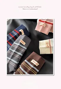 Nahaufnahme bunter gestreifter Baumwollsocken mit Serendipity-Stoffetiketten in verschiedenen Farben