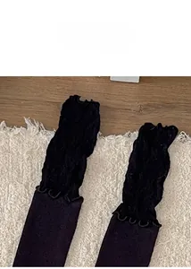 Gros plan détaillé de la dentelle noire et des volants plissés sur les chaussettes hautes