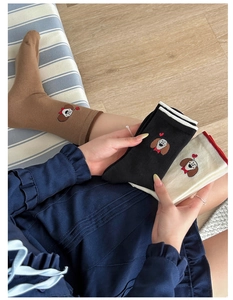 Détail de la broderie de chiot et motif cœur sur chaussettes en coton aux tons neutres