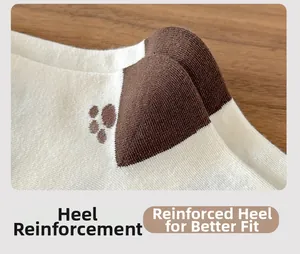 Close-up of beige cotton socks with brown paw prints and reinforced heel stitching details