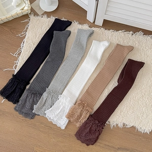 Over-the-knee socks with lace trim in six colors shown on a cozy carpet for winter fashion