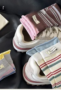 Detailansicht der happiness-Etiketten und gestreiften Textur der bunten Baumwollsocken