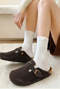 Macro view of white ribbed knit socks featuring a minimalist egg fabric label detail