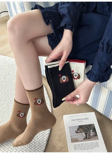 Détail de la broderie de chien colorée et des bords-côtes sur les chaussettes en coton