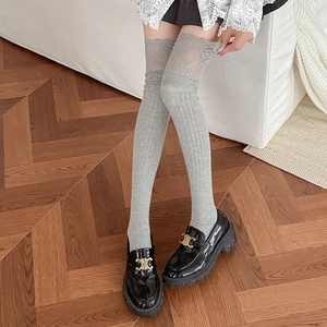 Grey over-knee socks with lace trim and ribbed texture paired with black chunky loafers
