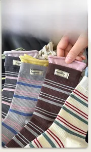 Nahaufnahme gestreifter Baumwollsocken mit Happiness-Label und Rippbündchen-Detail