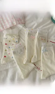 Nahaufnahme von weißen Netzsocken mit bunten Punkten und feinen Spitzenbesatz-Details
