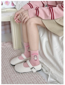 Detail of pink cotton socks featuring cute cartoon duck embroidery and music text detail