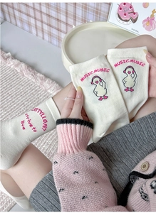 Close-up of cute cartoon duck embroidery and music letters on soft cotton socks