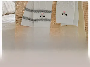 Détail de chaussettes en coton blanc avec broderie panda et bordure à volants gris