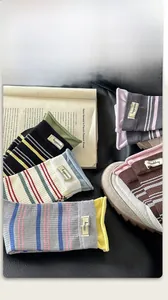 Detailansicht bunter gestreifter Socken mit Happiness-Stoffetikett auf Lederhintergrund