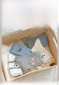 Gros plan de chaussettes en maille avec broderie chien mignon en gris, bleu et blanc