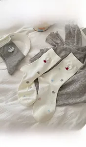 Detailed close-up of cute cartoon embroidered cotton socks in white and grey