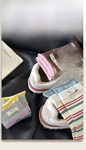 Detail von farbenfrohen gestreiften Socken mit Happiness-Etiketten und Strickstruktur