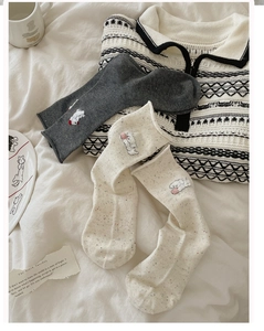 Detailed view of speckled knit crew socks featuring cute 3D puppy embroidery design