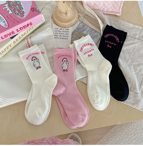 Flat lay of pink and white cotton crew socks with cute cartoon duck embroidery and rib cuffs