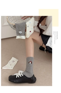 Close-up of cute cartoon puppy embroidery on grey ribbed cotton socks for women