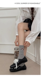 Detail of gray cotton crew socks with puppy embroidery paired with lace-up shoes