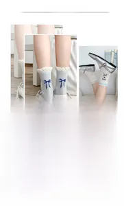Details von blauen Schleifenstickereien und weißen Rüschen an atmungsaktiven Socken