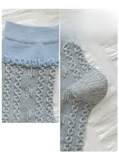Détail de chaussettes grises avec revers ondulés bleus et talon à coupe 3D ergonomique