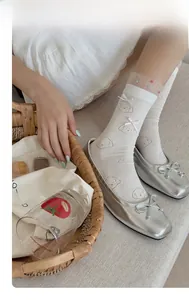 Nahaufnahme weißer Socken mit Bärenprint und 3D-Schleifen sowie Mesh-Abschluss