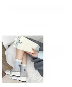 Detail von blau-beigen Netzsocken mit zarter Spitze und dekorativen Schleifen