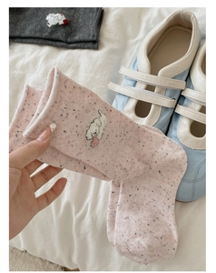 Detail of pink knit sock featuring cute animal embroidery and colorful speckled yarn texture