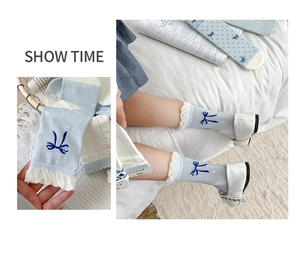 Detail mit blauem Schleifendruck und weißem Spitzenrand an bequemen Baumwollsocken