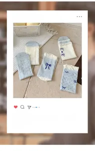 Detail von blau-weißen Socken mit Schleifenstickerei, Lochmuster und Rüschenspitzenkante