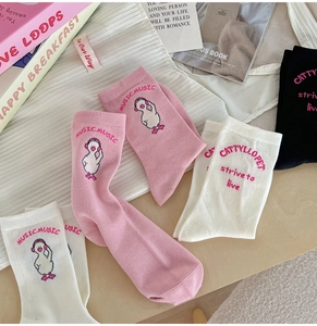 Close-up of pink and white cotton crew socks featuring cute cartoon duck and letter prints