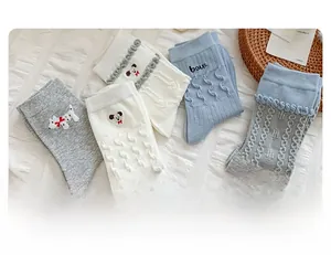 Détail de la broderie de chien mignon et de la maille torsadée sur les chaussettes en coton