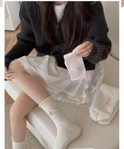 Detailed view of beige and pink crew socks with cute cartoon puppy embroidery accents