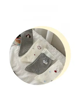 Detail of soft cotton crew socks with cute puppy, apple, and heart embroidery patterns