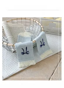 Detailansicht hellblauer Netzsocken mit gestickten Schleifen und weißem Spitzenbesatz