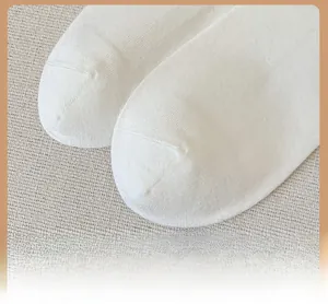 Close-up of reinforced toe stitching on white knitted cotton socks with fine texture