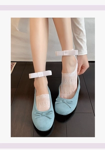 Detail of ballet style lace mesh socks with large silk bow paired with blue suede flats